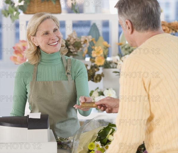 Female florist ringing up customer.