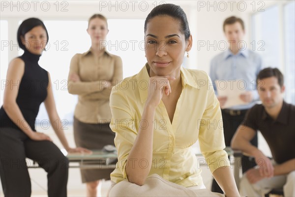 Portrait of businesswoman with coworkers in background.
