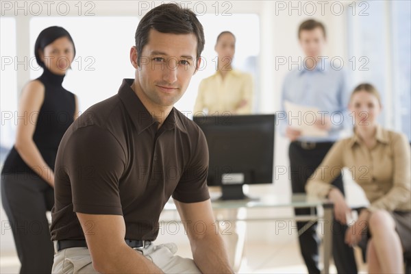 Portrait of businessman with coworkers in background.