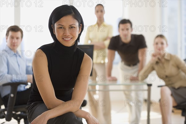 Portrait of businesswoman with coworkers in background.