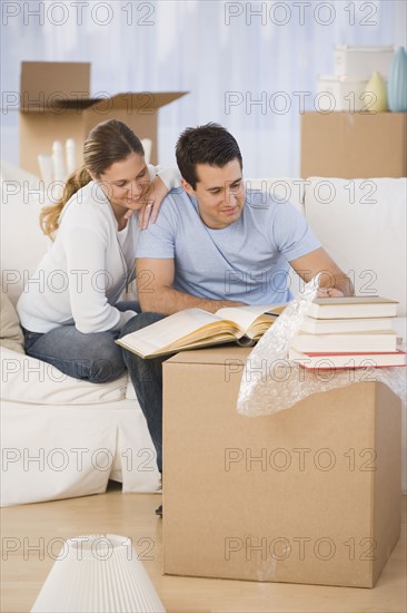 Couple unpacking books in new house.