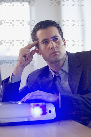 Businessman using projector in conference room.