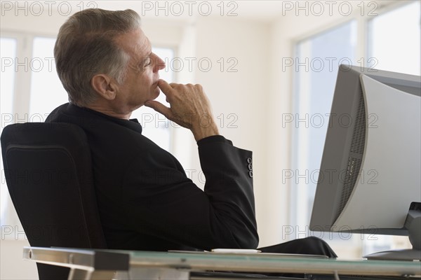 Senior businessman sitting at desk.