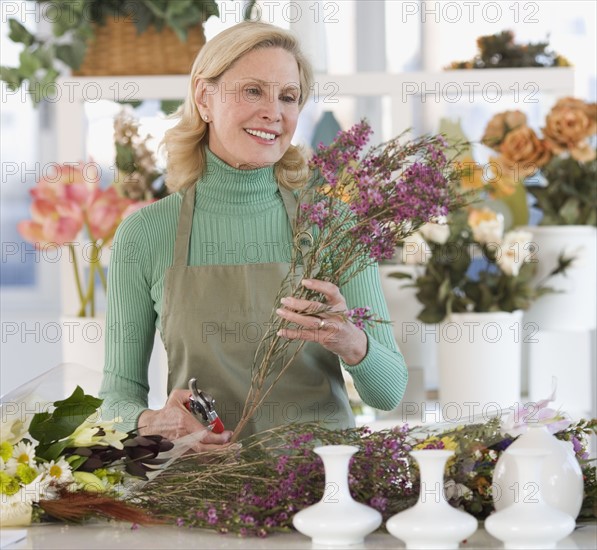 Female florist cutting flowers.