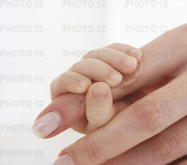 Baby holding mother’s finger.