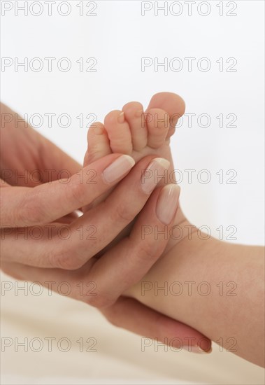 Mother holding baby’s foot.
