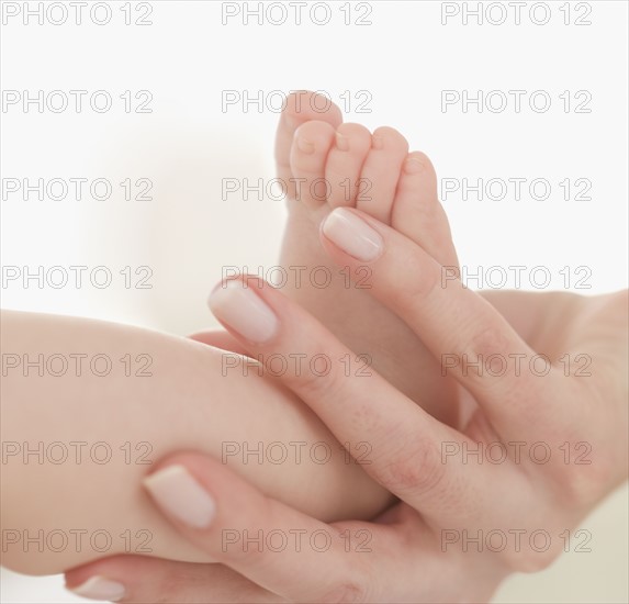 Close up of mother holding baby's foot.