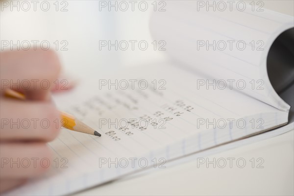Close up of woman writing in notebook.