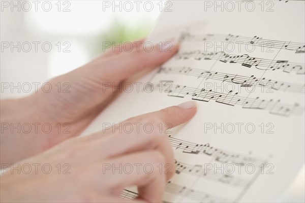 Close up of woman pointing at sheet music.