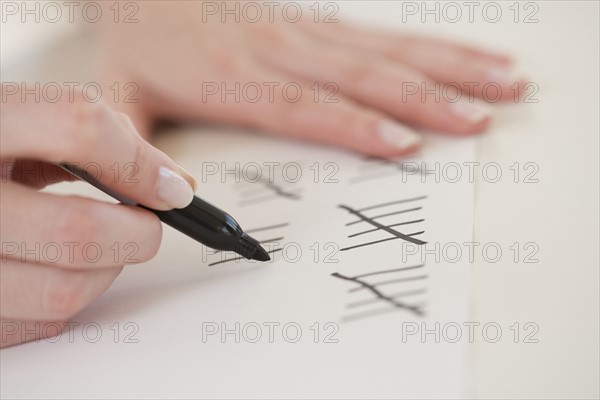 Close up of woman counting on paper.