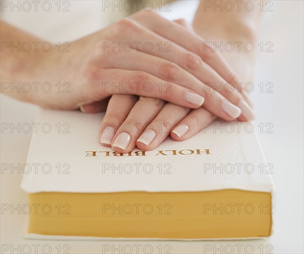 Woman's hands on Bible.