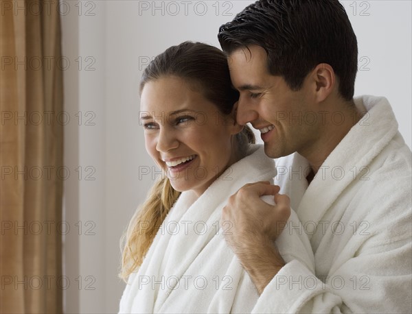 Couple in bathrobes hugging.