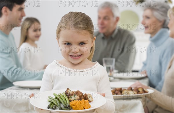 Portrait of girl holding plate at Thanksgiving.