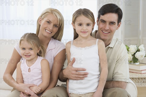 Portrait of family on sofa.