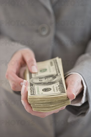 Businesswoman holding stack of money.