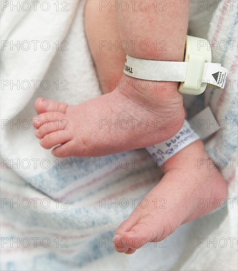 Newborn baby's feet with hospital tags.