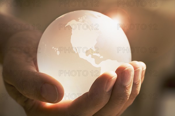 Close up of man holding glass globe.