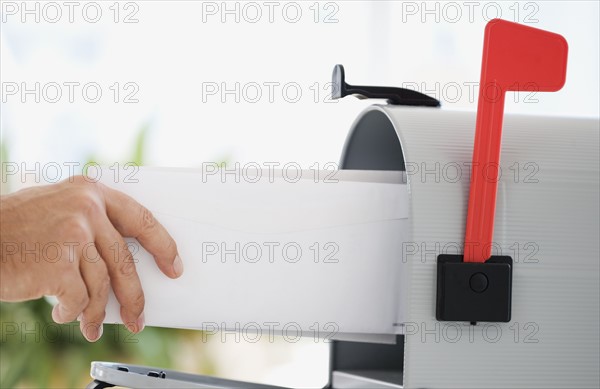 Man putting mail in mailbox.