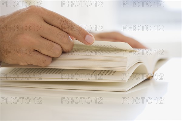 Man turning page of book.