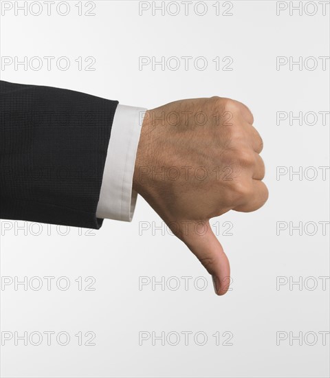 Studio shot of businessman's hand giving thumbs down.