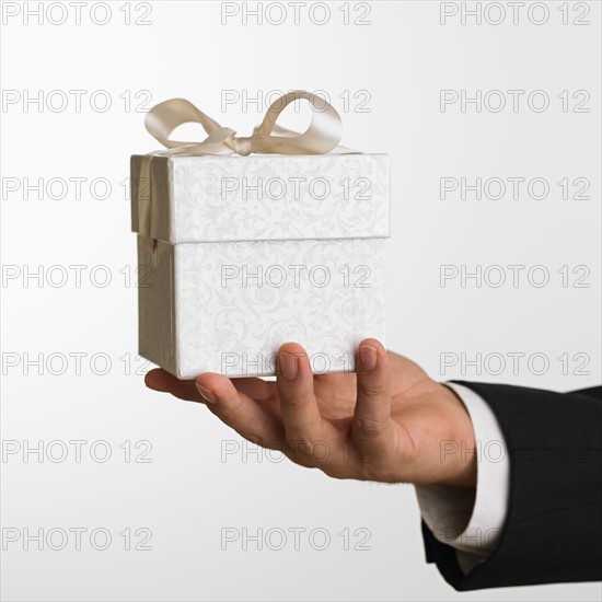 Close up studio shot of man holding gift.