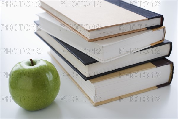 Stack of books and apple.