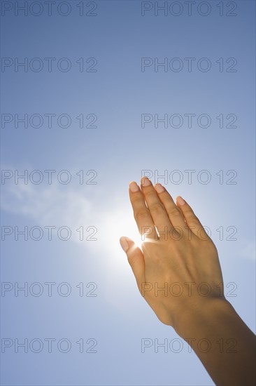 Close up of woman's hand blocking sun.