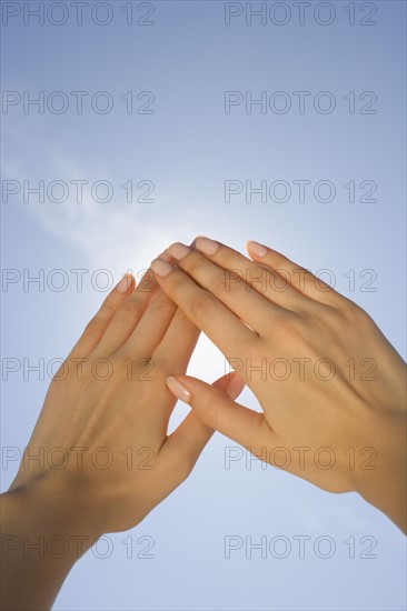 Close up of woman's hands blocking sun.