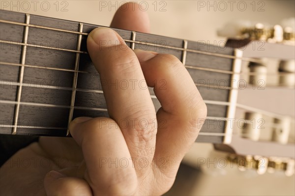 Close up of man's hand playing guitar.
