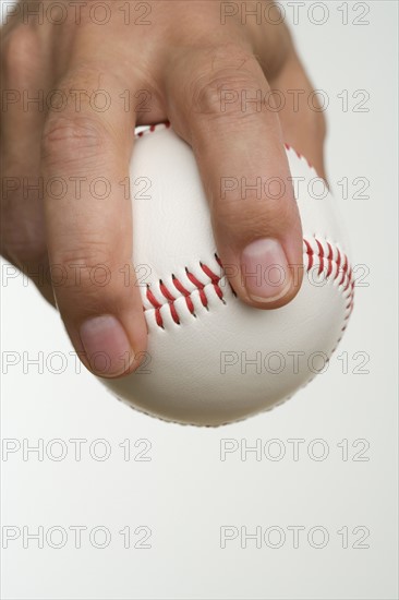 Close up of pitcher holding baseball.