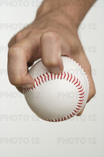 Close up of pitcher holding baseball.