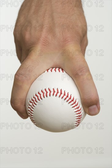 Close up of pitcher holding baseball.