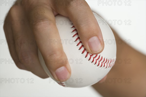 Close up of pitcher holding baseball.