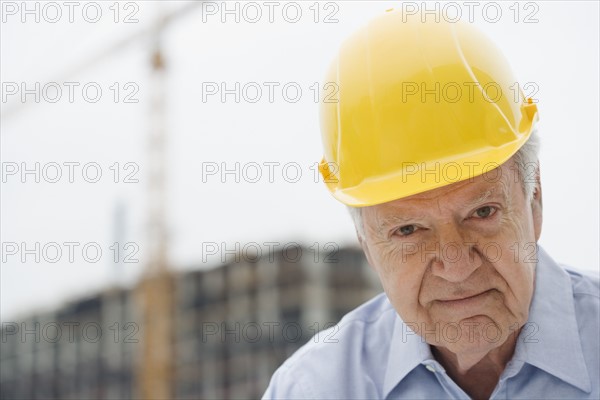 Senior man wearing hard hat.