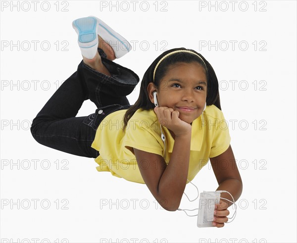 Studio shot of girl listening to mp3 player.