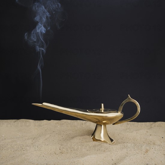 Close up of incense burner on sand.