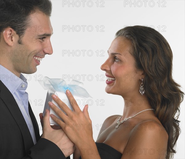 Studio shot of man giving woman gift.