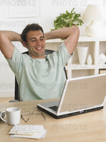 Man using laptop at table.