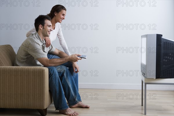 Couple on sofa watching television.