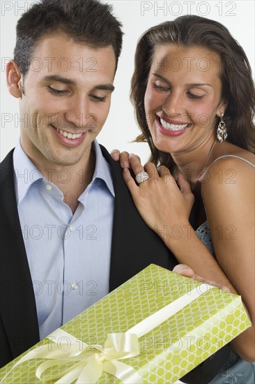 Woman giving man gift.