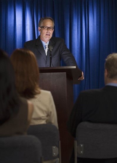 Businessman speaking at podium.