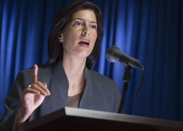 Close up of businesswoman speaking at podium.