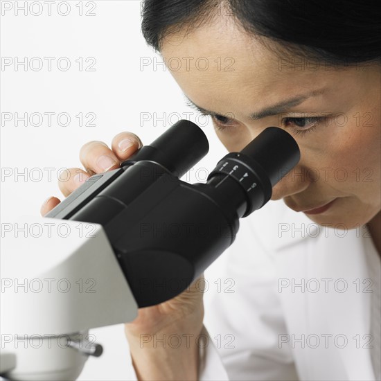 Close up of woman looking in microscope.