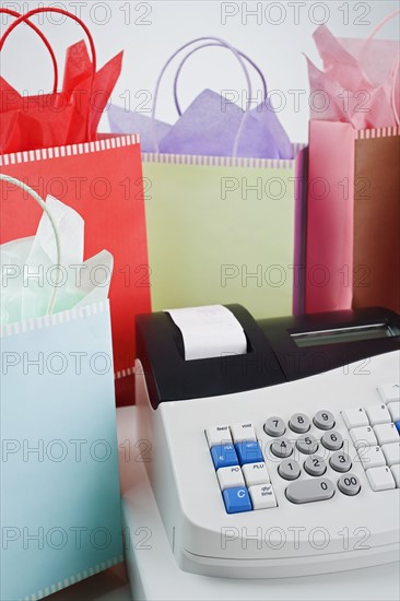 Cash register surrounded by gift bags.