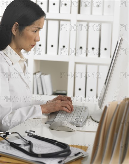 Female doctor using computer.