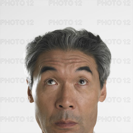 Studio shot of middle-aged man looking up .