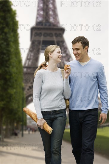 Couple walking with Eiffel Tower in background.