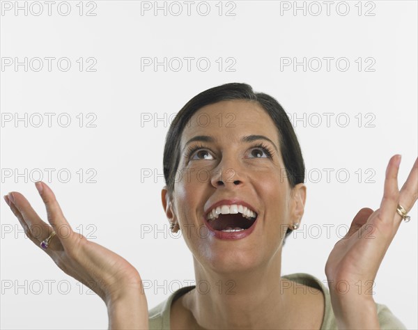 Studio shot of woman laughing and looking up.