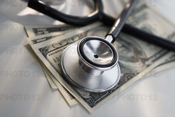 Close up of stethoscope and US dollars.