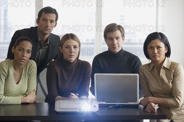 Group of businesspeople using projector at meeting.